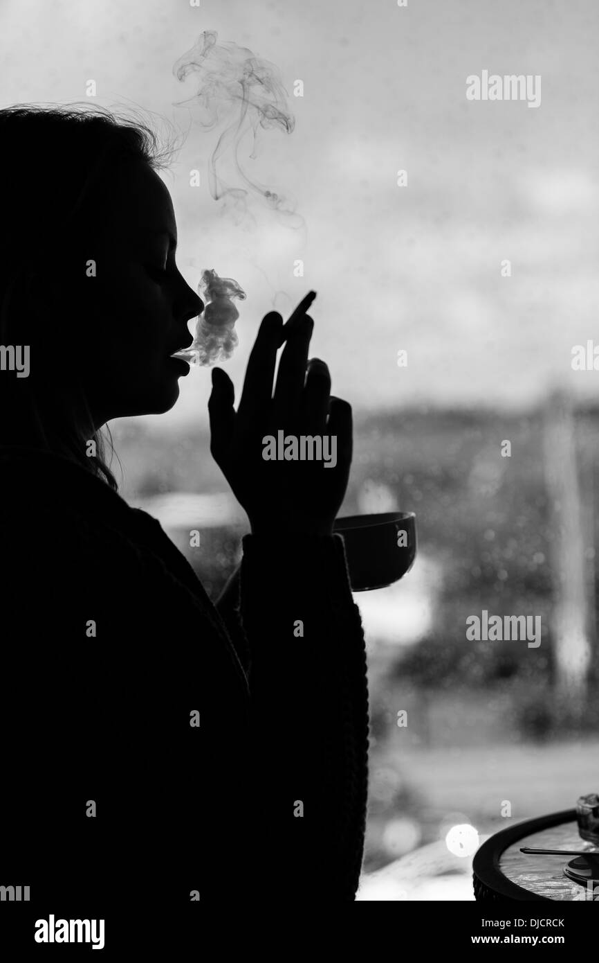 Silhouette einer attraktiven Frau Rauchen Zigarette Stockfoto