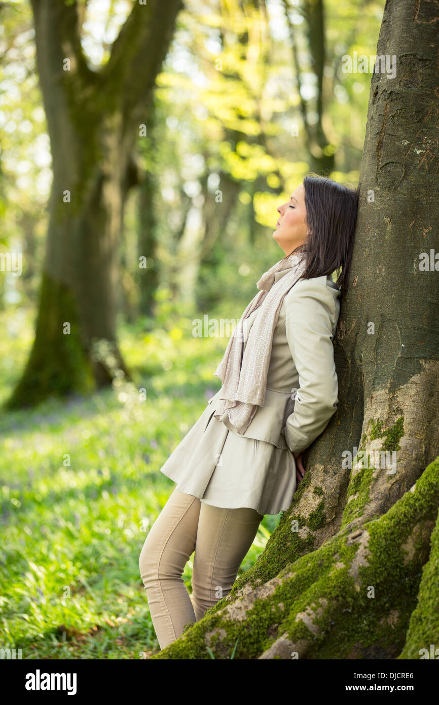 Frau an einem Baum gelehnt Stockfoto