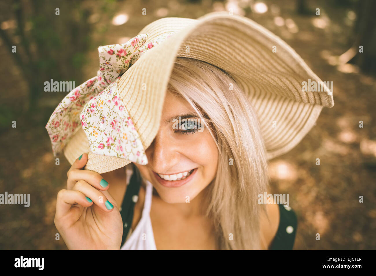 Wunderschöne Blondine mit Stroh Hut lächelnd Stockfoto