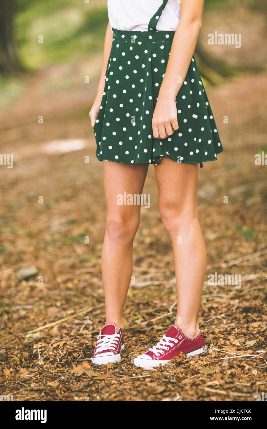 Junge Frau trägt gepunkteten Rock stehend Stockfoto