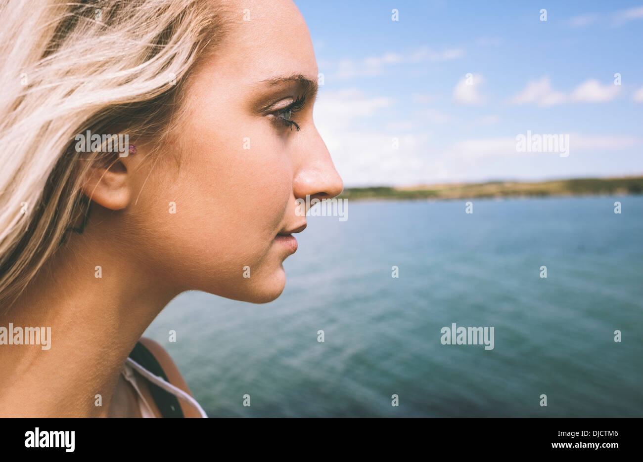 Wunderschöne Blondine mit Blick auf See Stockfoto