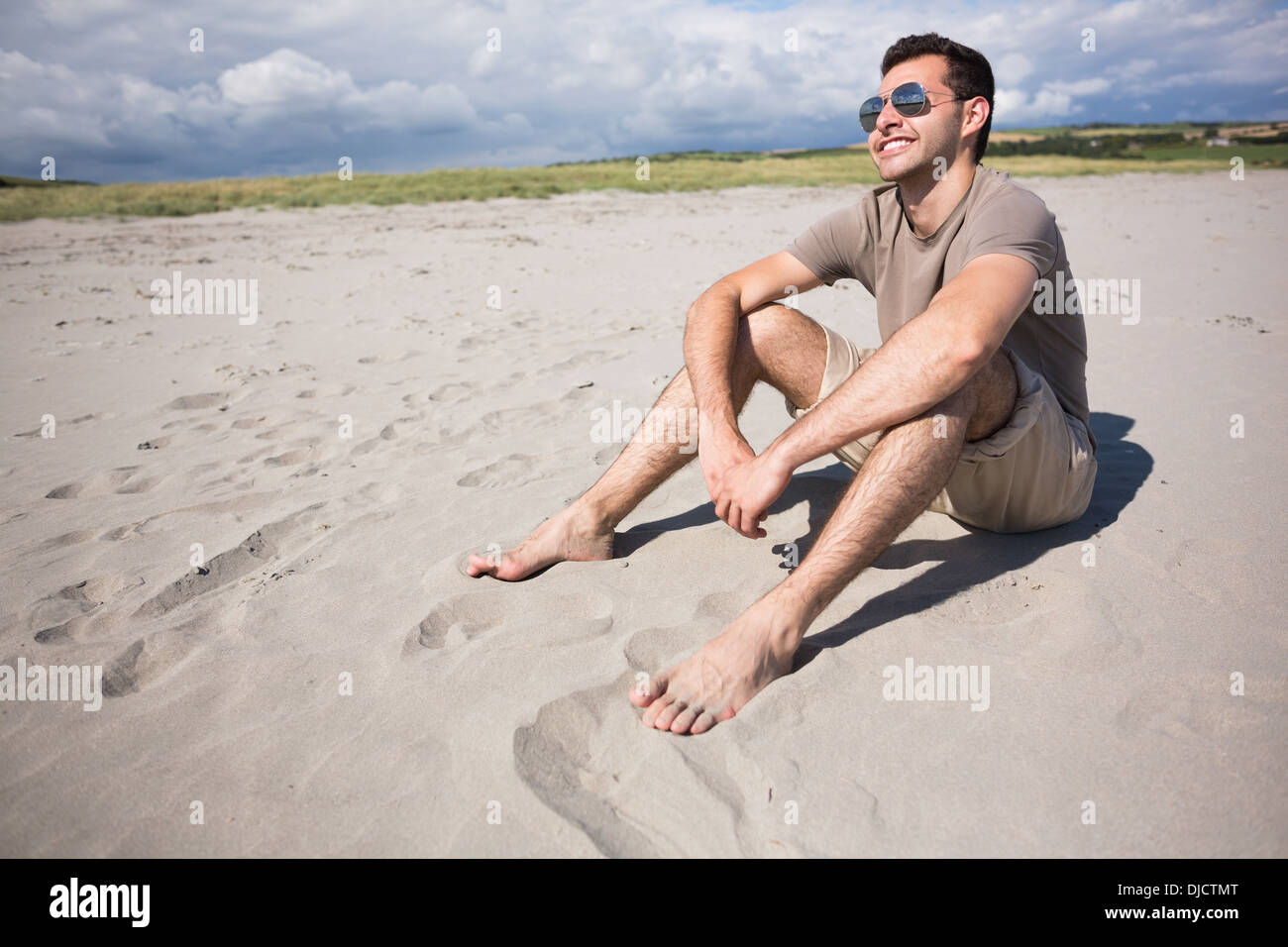 Attraktives Lächeln Mann sitzen und die Sonne genießen Stockfoto