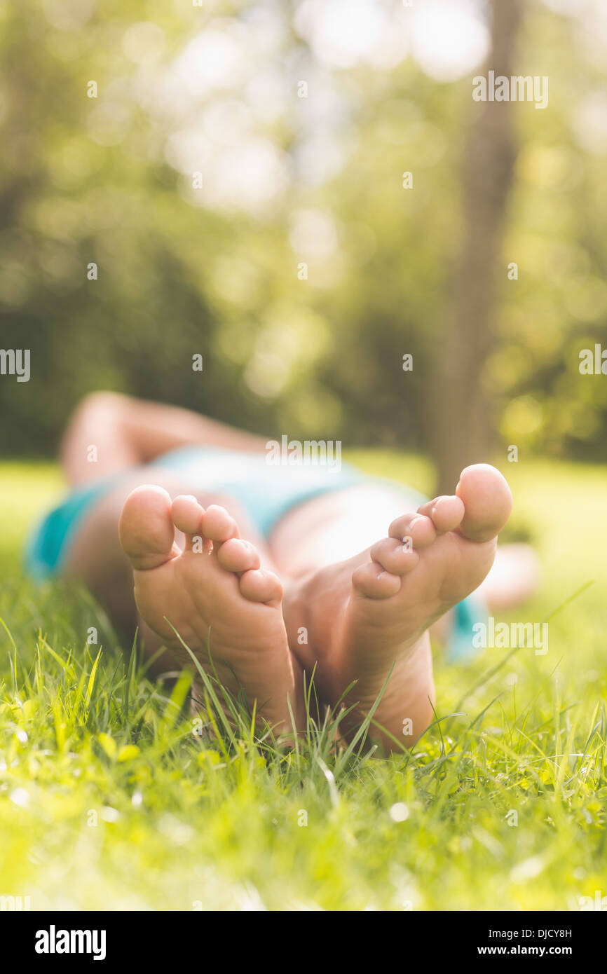 Nahaufnahme von weiblicher Füße liegen auf dem Rasen Stockfoto