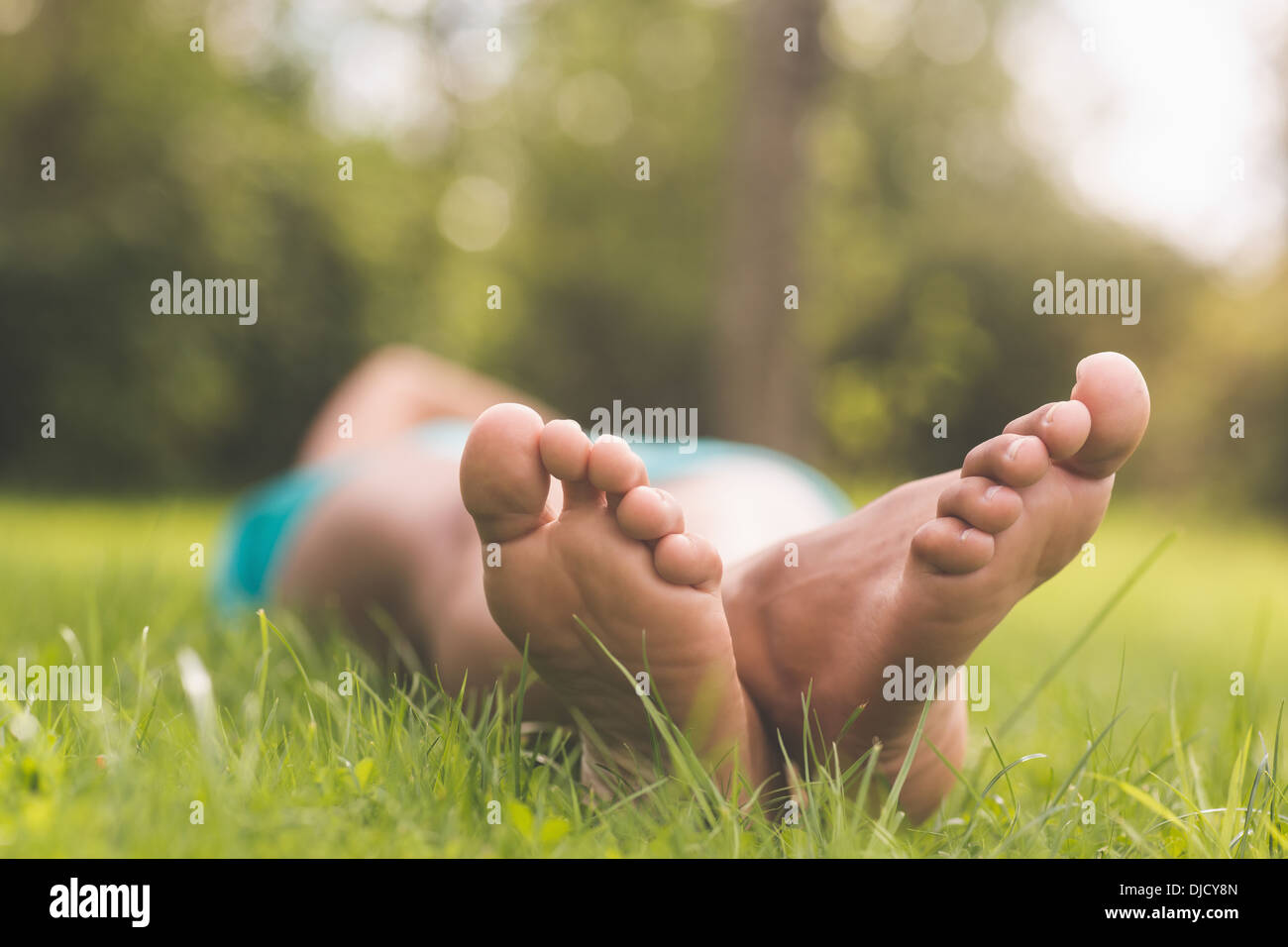 Bild weiblicher Füße liegen auf dem Rasen Stockfoto