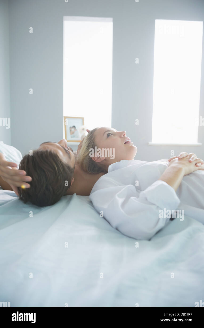 Attraktive Frau liegt auf ihrem Bett mit ihrem Freund Stockfoto