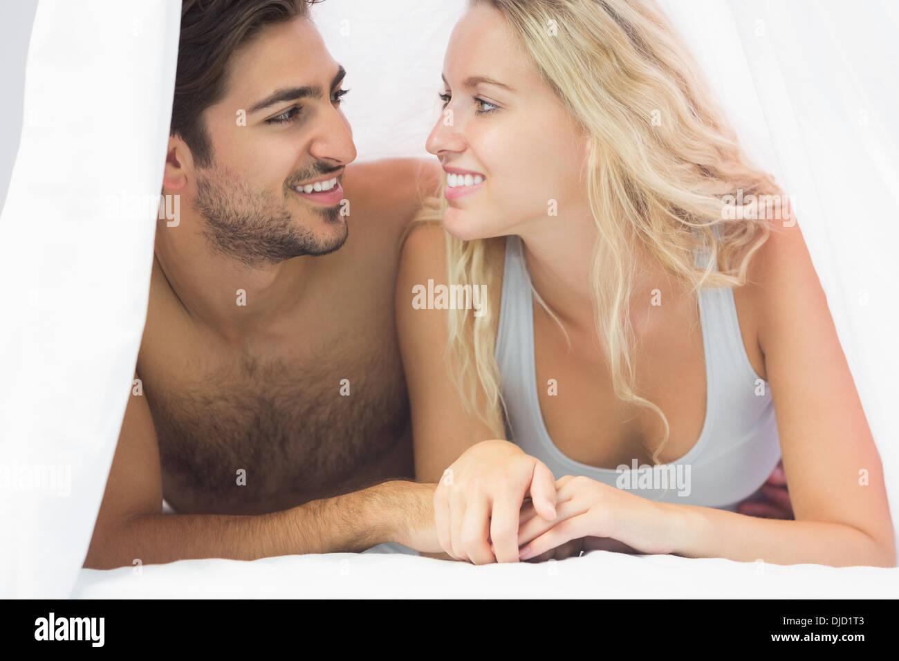 Nettes junges Paar auf ihrem Bett liegend Stockfoto