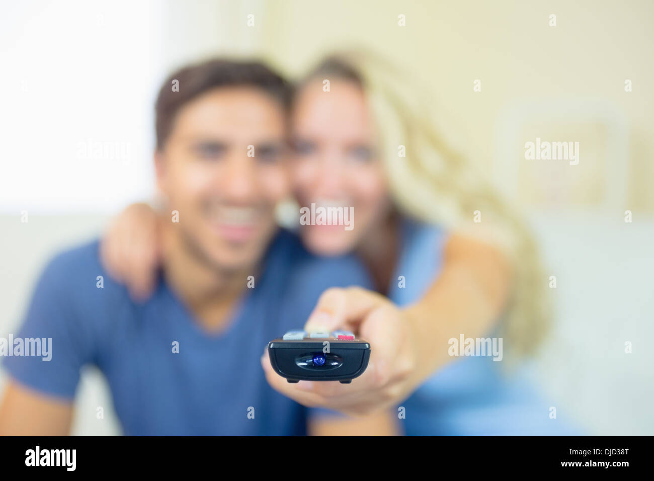 Lächelnd junges Paar vor dem Fernseher im Wohnzimmer Stockfoto