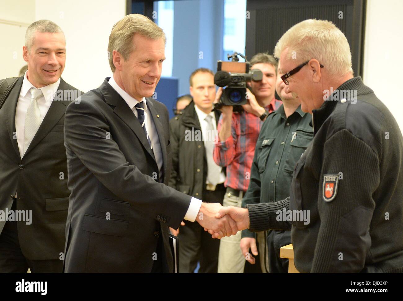 Hannover, Deutschland. 27. November 2013. Der ehemalige deutsche Bundespräsident Christian Wulff begrüßt einen Gerichtsvollzieher in das Landgericht Hannover, 27. November 2013. Der ehemalige Präsident hat für die Annahme von Gefälligkeiten zu beantworten. Foto: HOLGER HOLLEMANN/Dpa/Alamy Live News Stockfoto