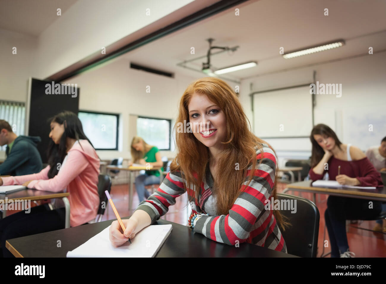 Lächelnde Studentin Blick in die Kamera in der Klasse Stockfoto