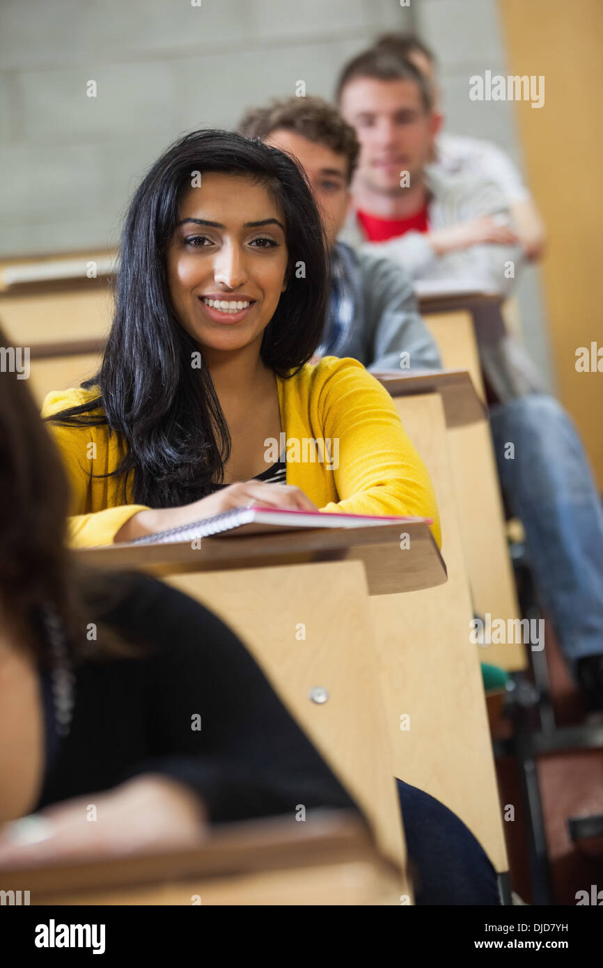 Lächelnde indischer Student Notizen im Hörsaal Stockfoto