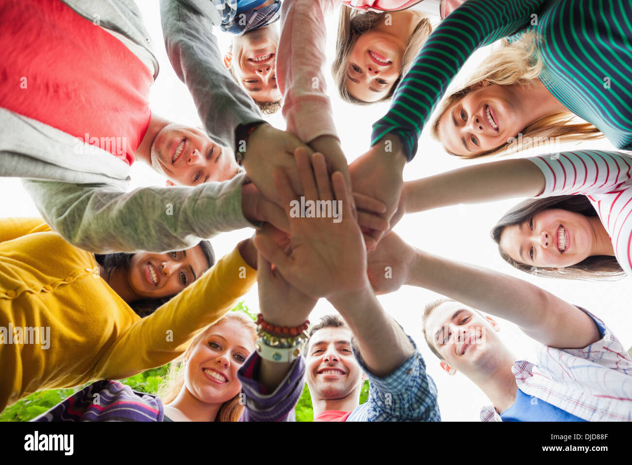 Gruppe von glücklichen Studenten setzen Hände in einem Kreis auf dem campus Stockfoto