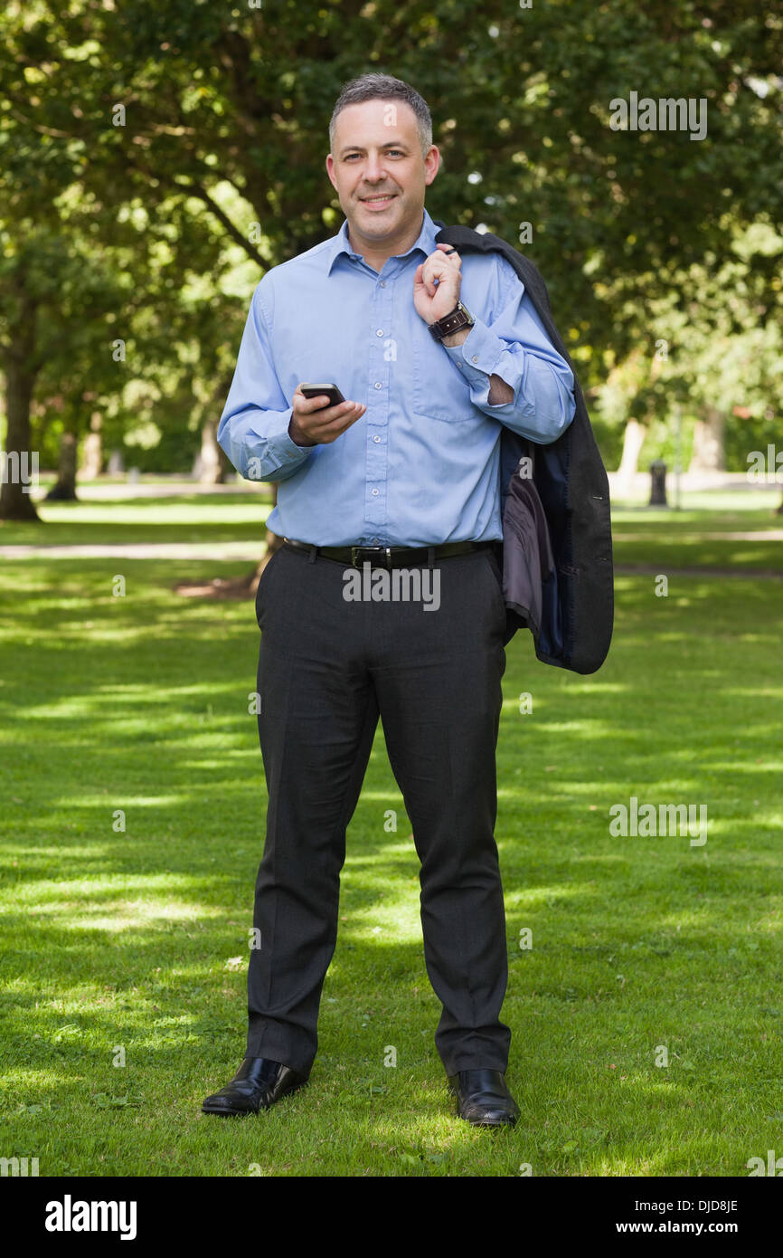 Lächelnde Professor stehend auf dem Campus SMS auf dem Handy Stockfoto