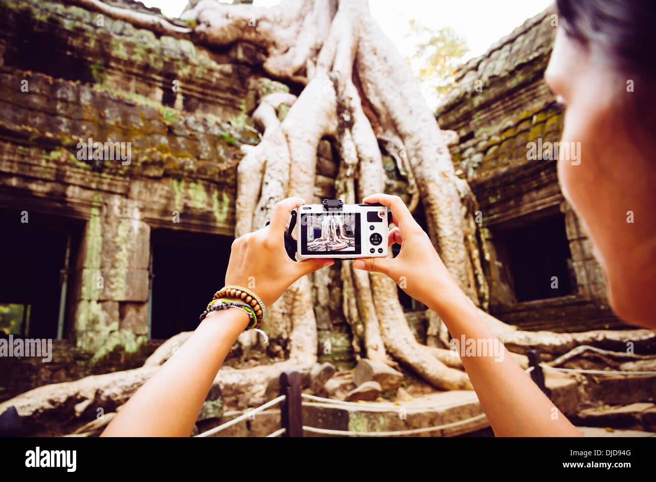 Kambodscha, Angkor Wat, Frau nimmt Bilder von der berühmten Baum in Ta Prohm Tempel Stockfoto