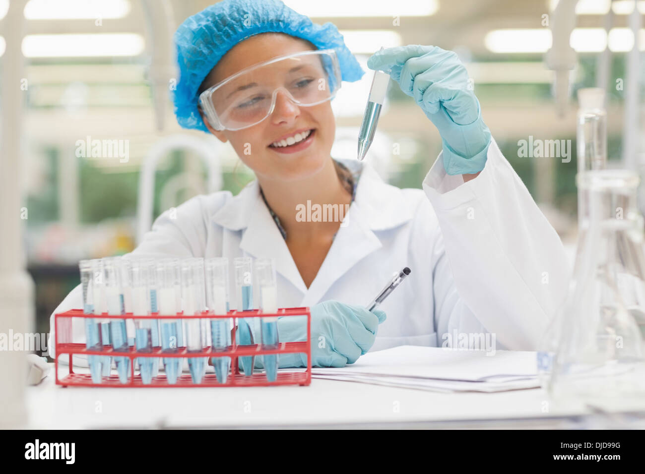 Lächelnd Student Holding Reagenzglas mit Flüssigkeit Stockfoto