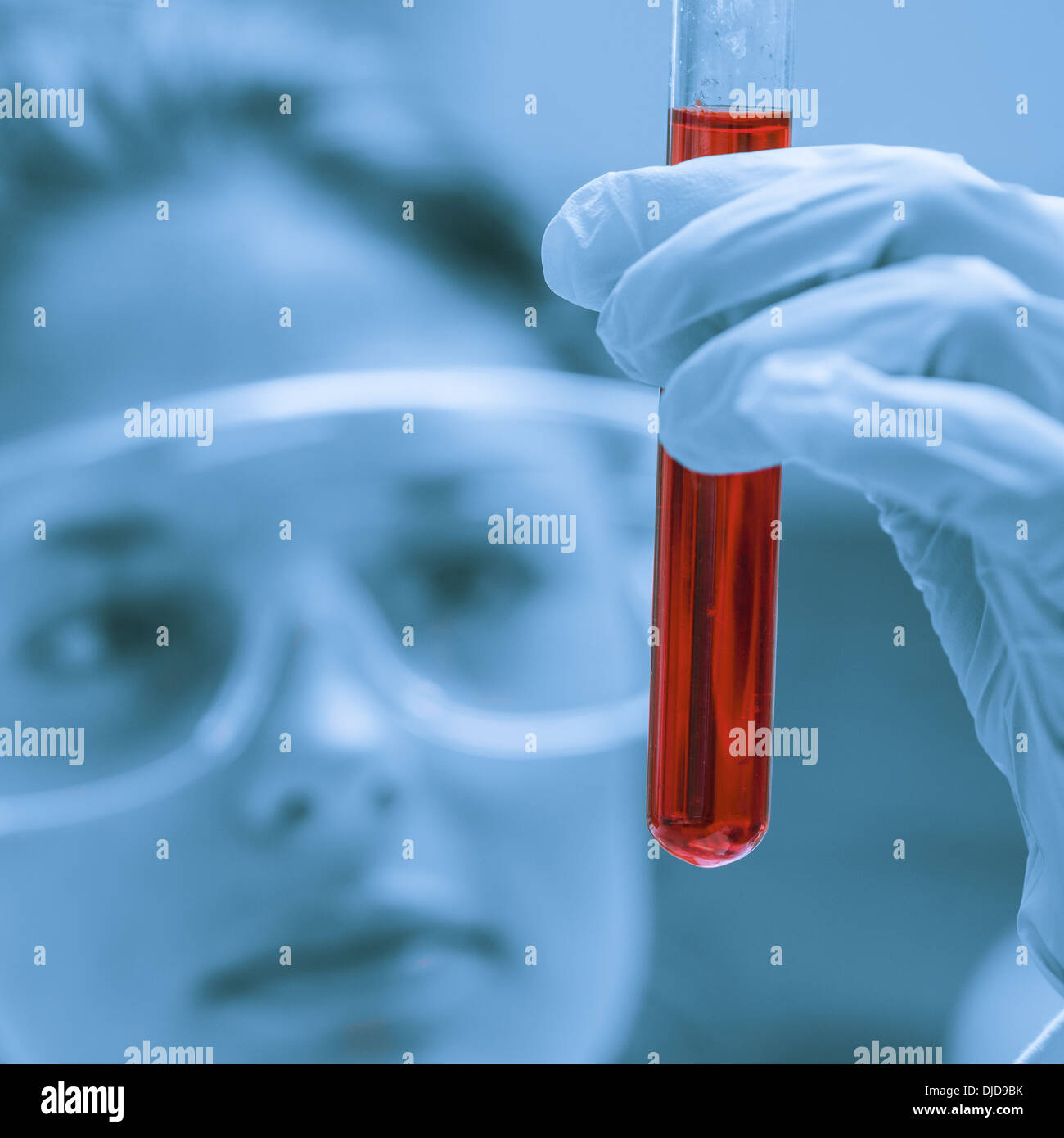 Student hält Reagenzglas mit roter Flüssigkeit Stockfoto