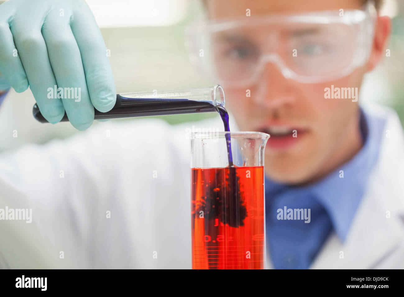 Erstaunt Student Gießen purpurrote Flüssigkeit in rot Stockfoto