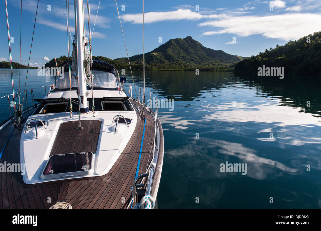 Morgenlicht, Reflexionen über die Umgebungen Hügel und eine Yacht vor Anker in der Lagune, aus dem Dorf Lomati, Matuku. Fidschi-Inseln Stockfoto
