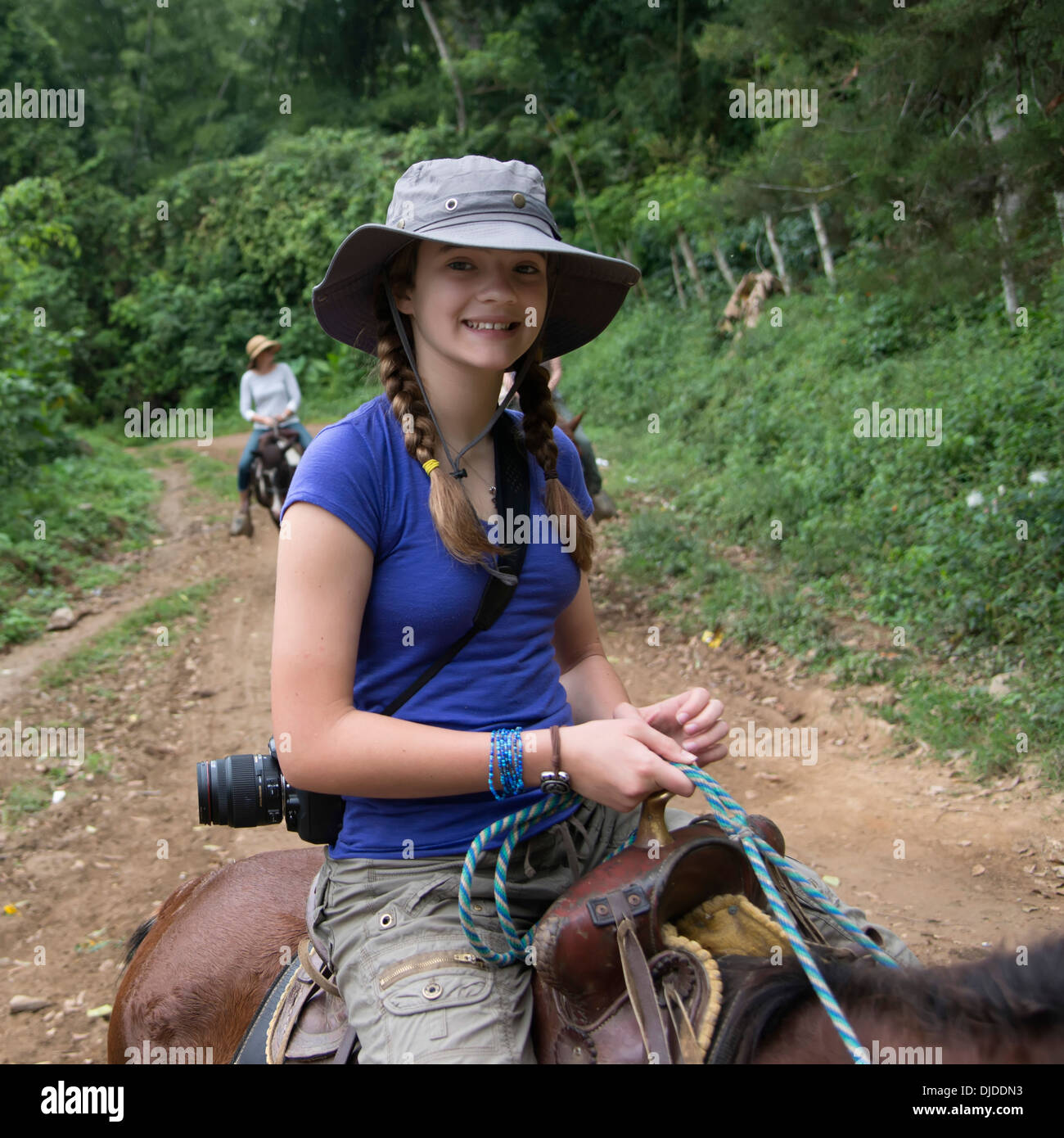 Ein Mädchen auf einem Pferd auf einem Weg; Finca El Cisne, Honduras Stockfoto