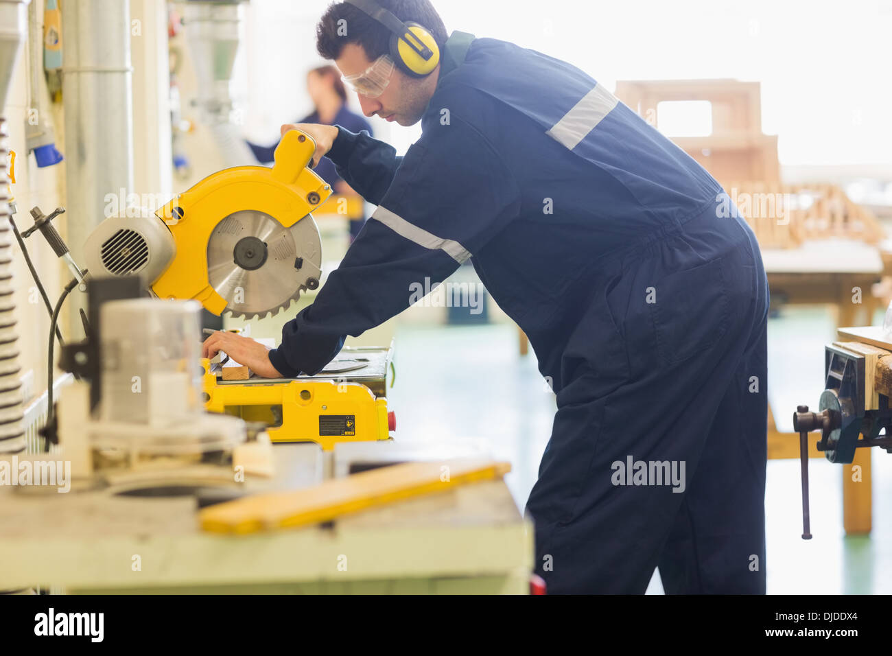 Handwerker mit Schutzbrille Holz Sägen Stockfoto