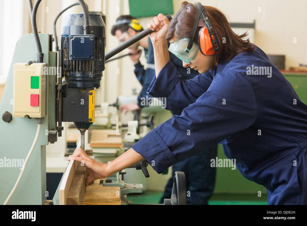 Trainee bei der Schutzbrille Bohren Holz Stockfoto