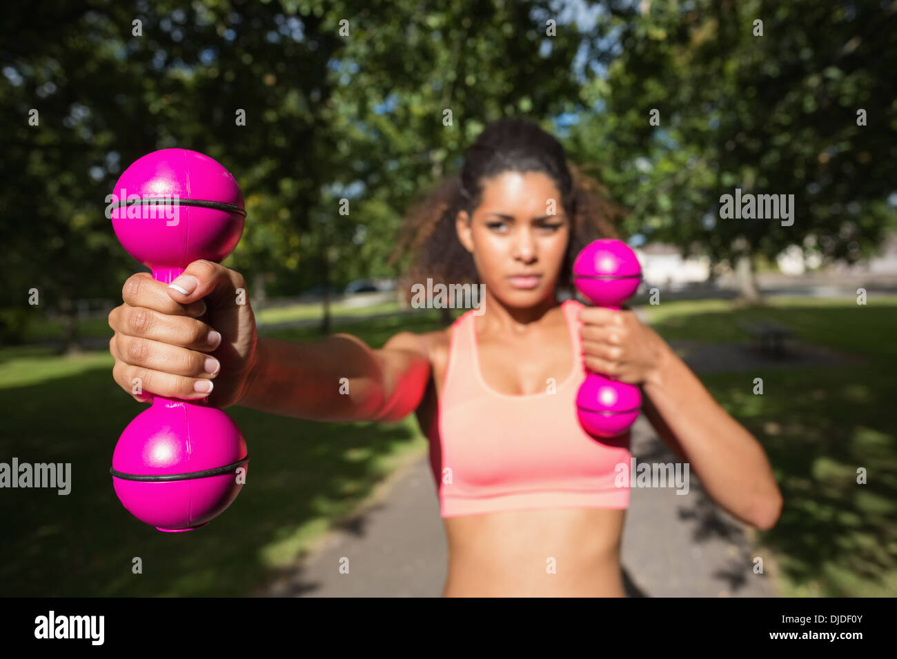 Fit junge Frau, die das Training mit Hanteln im park Stockfoto