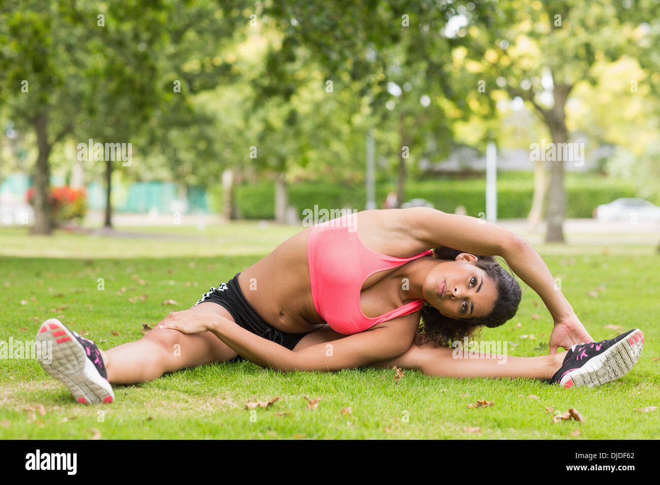 Straff und flexible Frau tun stretching-Übung im park Stockfoto