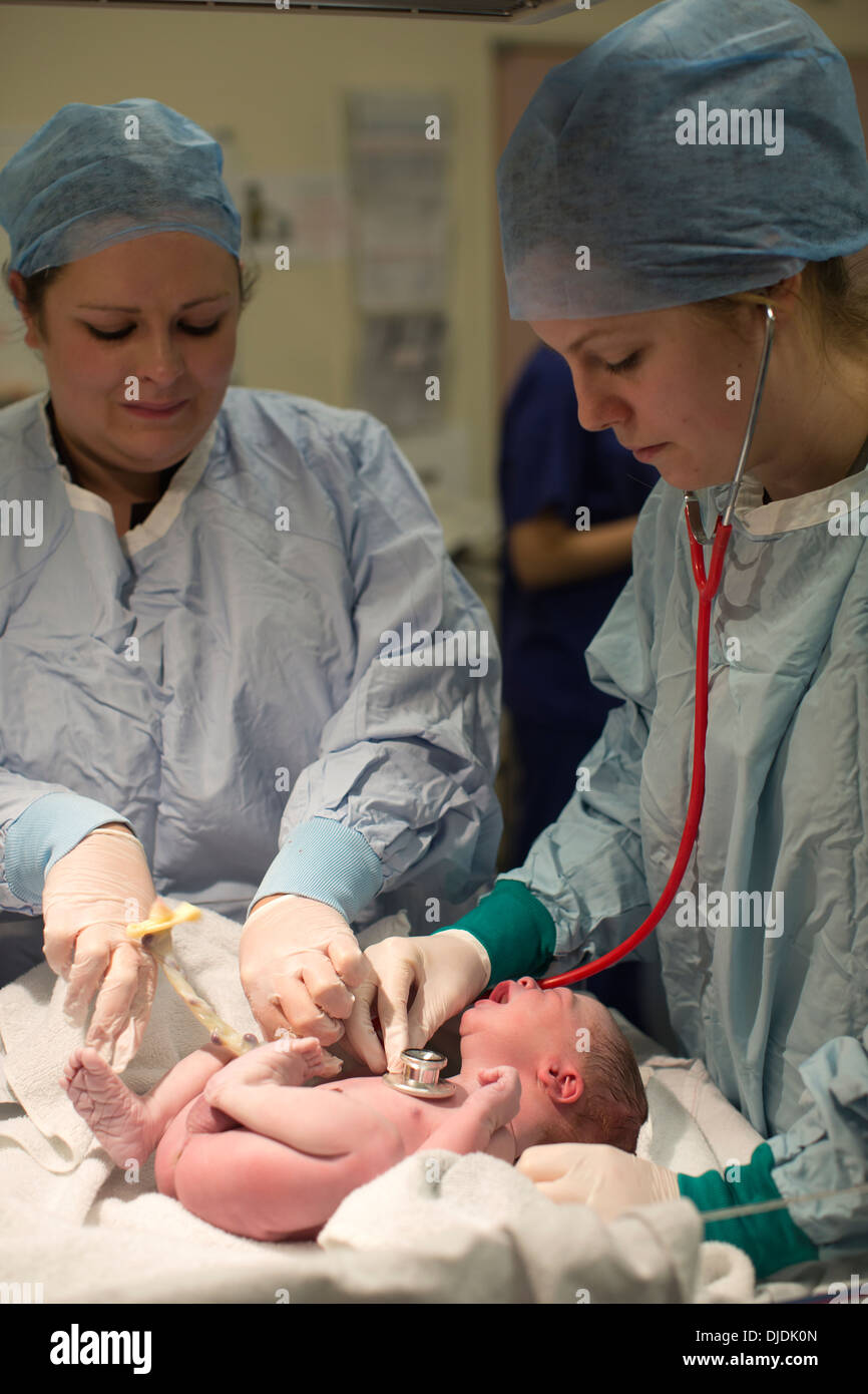 Neugeborenes Baby Boy geprüft von Krankenschwestern im Krankenhaus Mutterschaft Theater auf der Arbeit-Station im Krankenhaus, Kingston nach Themse, UK Stockfoto