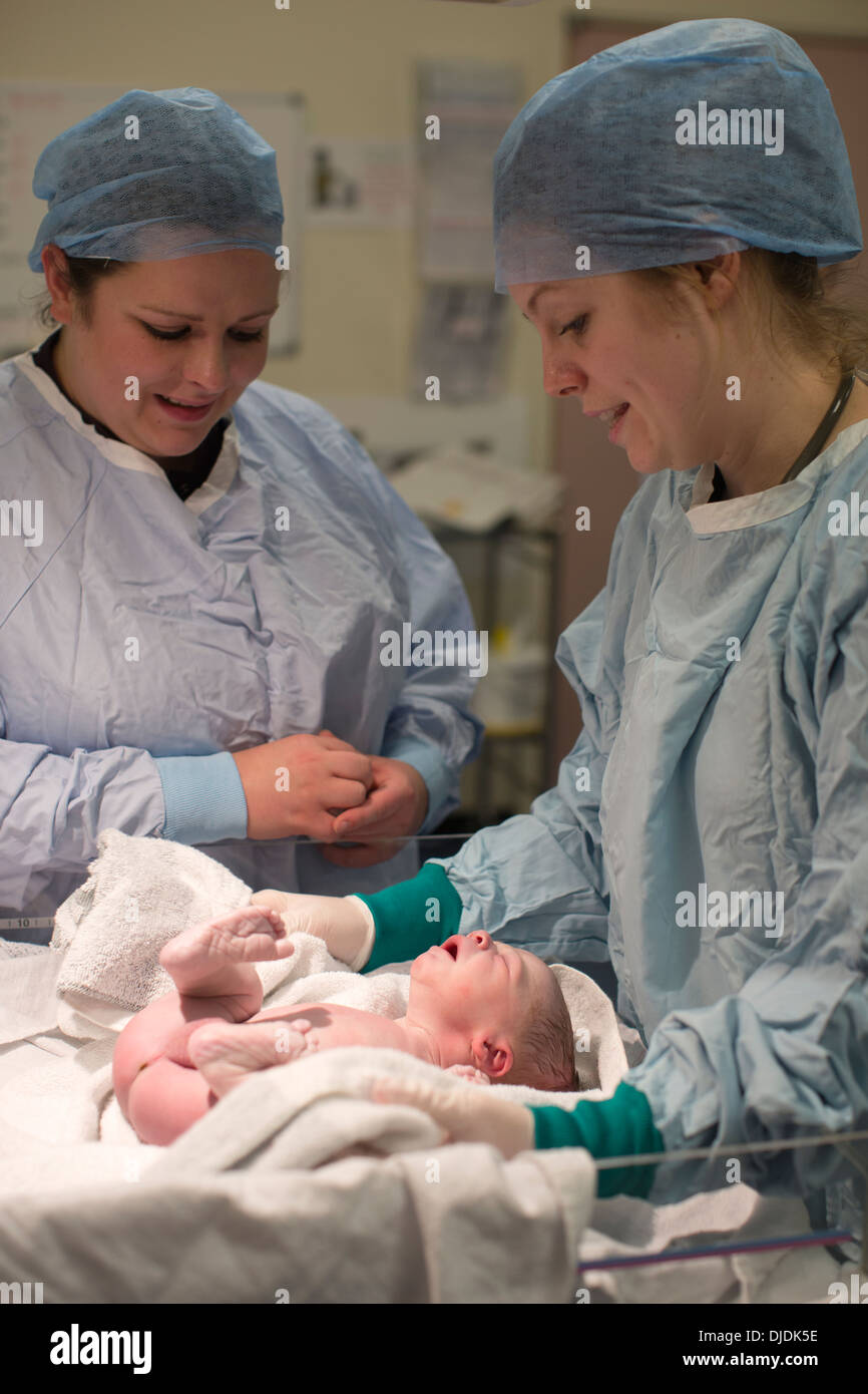 Neugeborenes Baby Boy geprüft von Krankenschwestern im Krankenhaus Mutterschaft Theater auf der Arbeit-Station im Krankenhaus, Kingston nach Themse, UK Stockfoto
