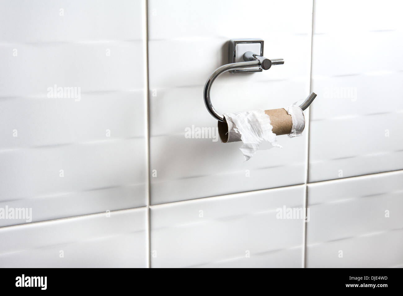 Leere Toilettenpapierrolle auf Halter. Peinliches Problem, schwierige Situation. Stockfoto