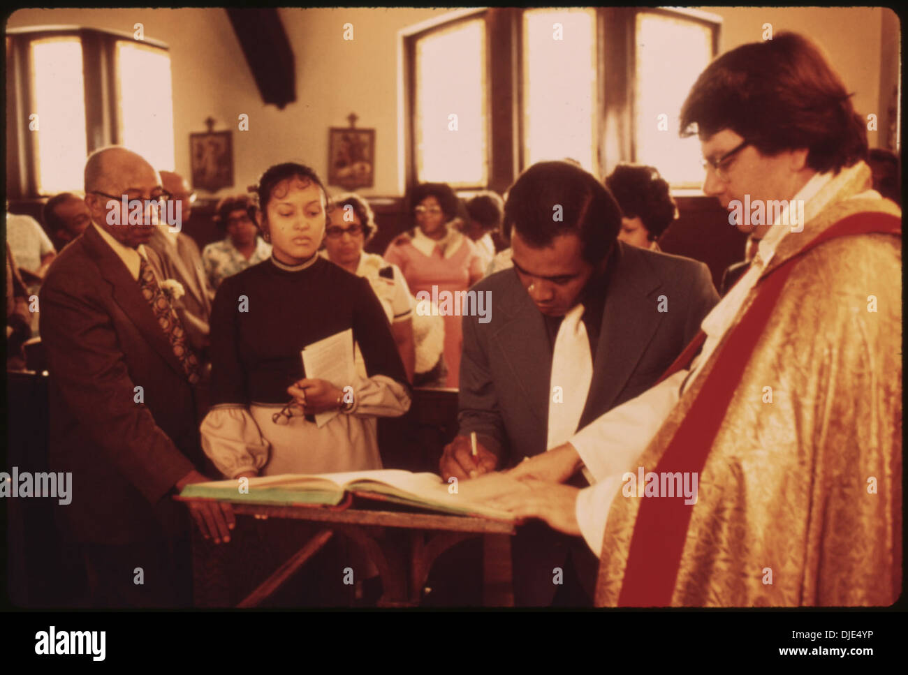 Eine schwarze Familie unterschreibt das Kirchenregister der Messias-Kirche nach einer Baby-Taufe. Diese Veranstaltung spiegelt die Bedeutung religiöser Rituale und Gemeindeverbundenheit im Familienleben wider. Stockfoto Eine schwarze Familie unterschreibt das Kirchenregister der Messias-Kirche nach einer Baby-Taufe. Diese Veranstaltung spiegelt die Bedeutung religiöser Rituale und Gemeindeverbundenheit im Familienleben wider. Stockfoto