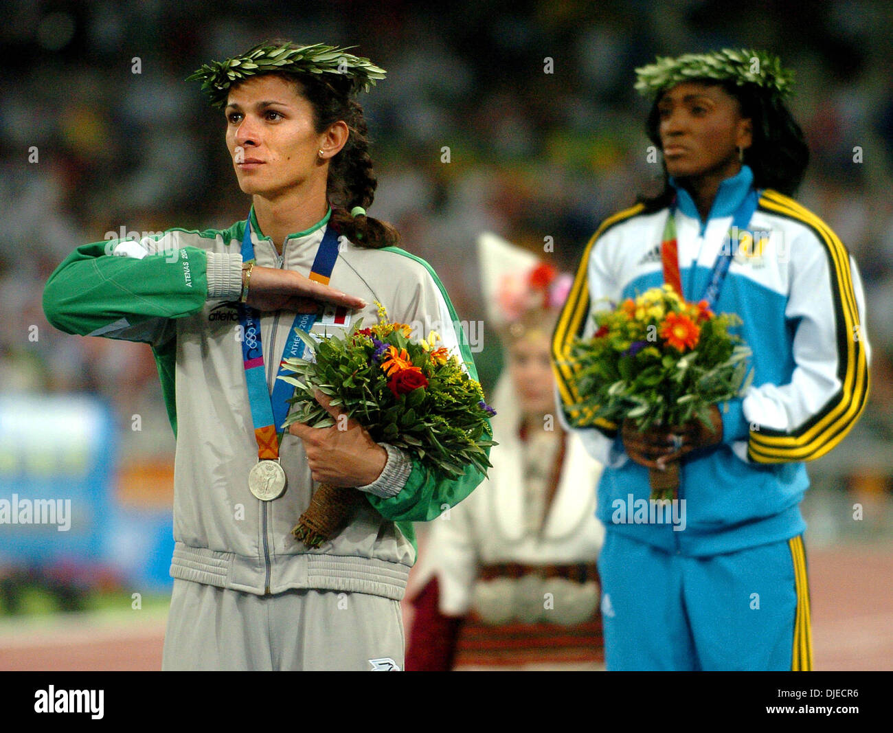 24. August 2004; Athen, Griechenland;  Mexikos ANA GUEVARA deckt ihr Herz Dienstag, 24. August 2004 in Athen während des Abspielens der Nationalhymne Bahamas während der Preisverleihung für die 400-Meter-Lauf während der Olympiade XXVIII. Guevarra wurde Zweiter mit einer Zeit von 49,56 Sekunden hinter TONIQUE WILLIAMS-DARLING. Stockfoto