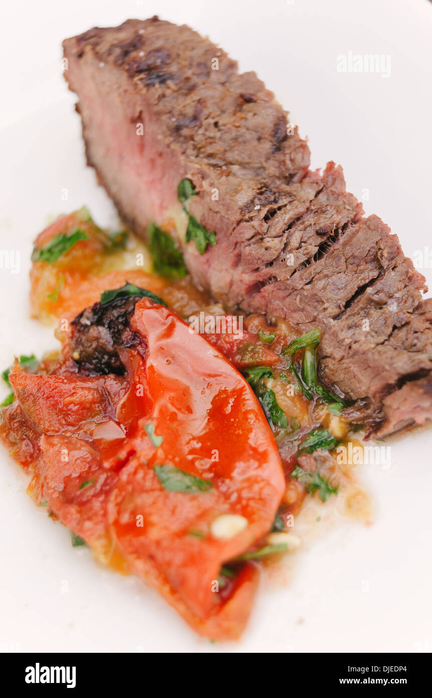 Scheibe Fleisch mit scharfer Salsa auf weißen Teller gekocht. Stockfoto