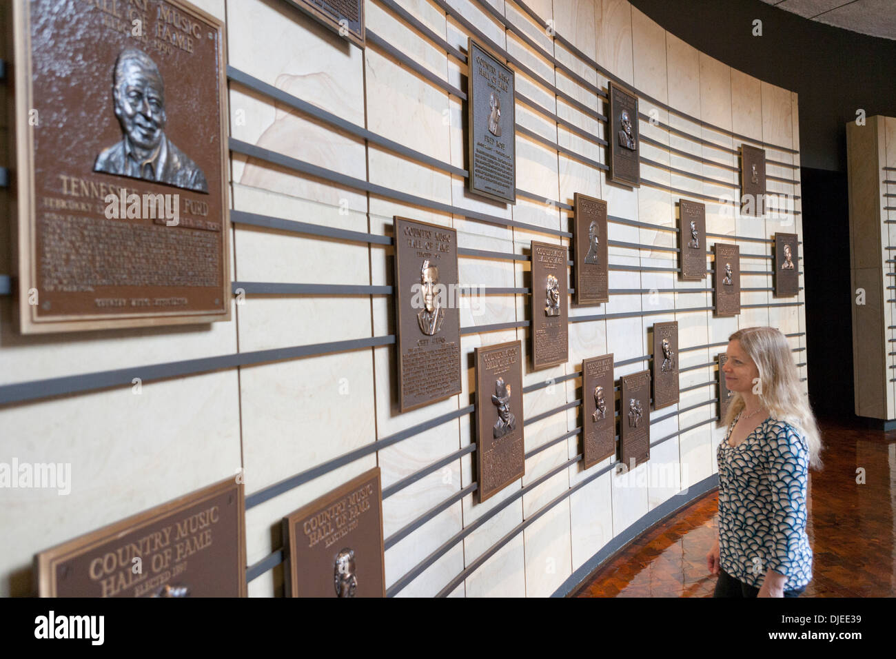 Eine Frau schaut die Plaques gewidmet Country Musikstars an einer Wand in die Country Music Hall Of Fame in Nashville, TN. Stockfoto