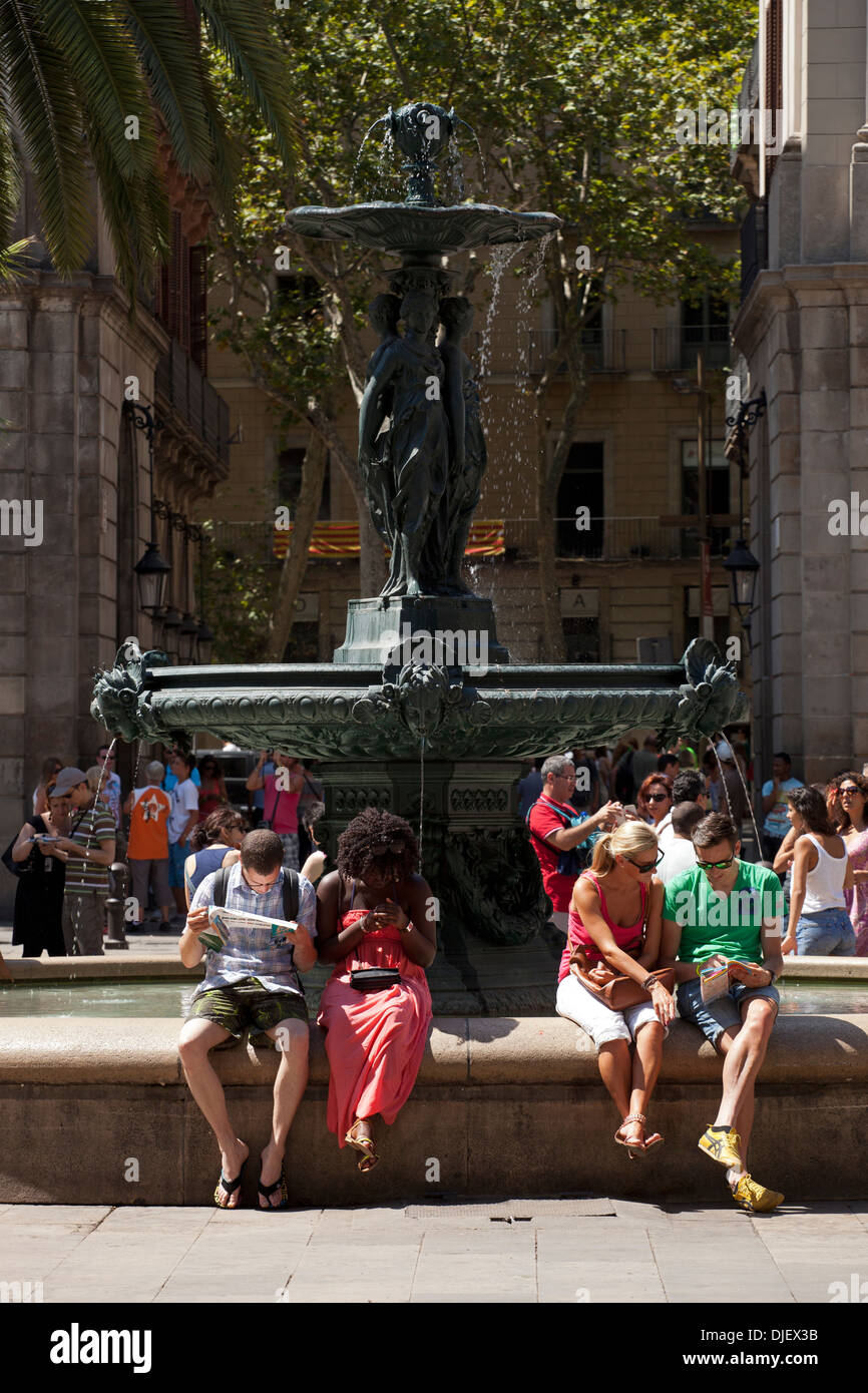 Entspannende Touristen am Brunnen im Plaza Real, Barcelona Stockfoto
