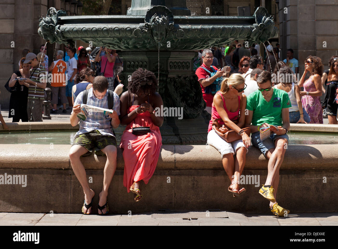 Entspannende Touristen am Brunnen im Plaza Real, Barcelona Stockfoto