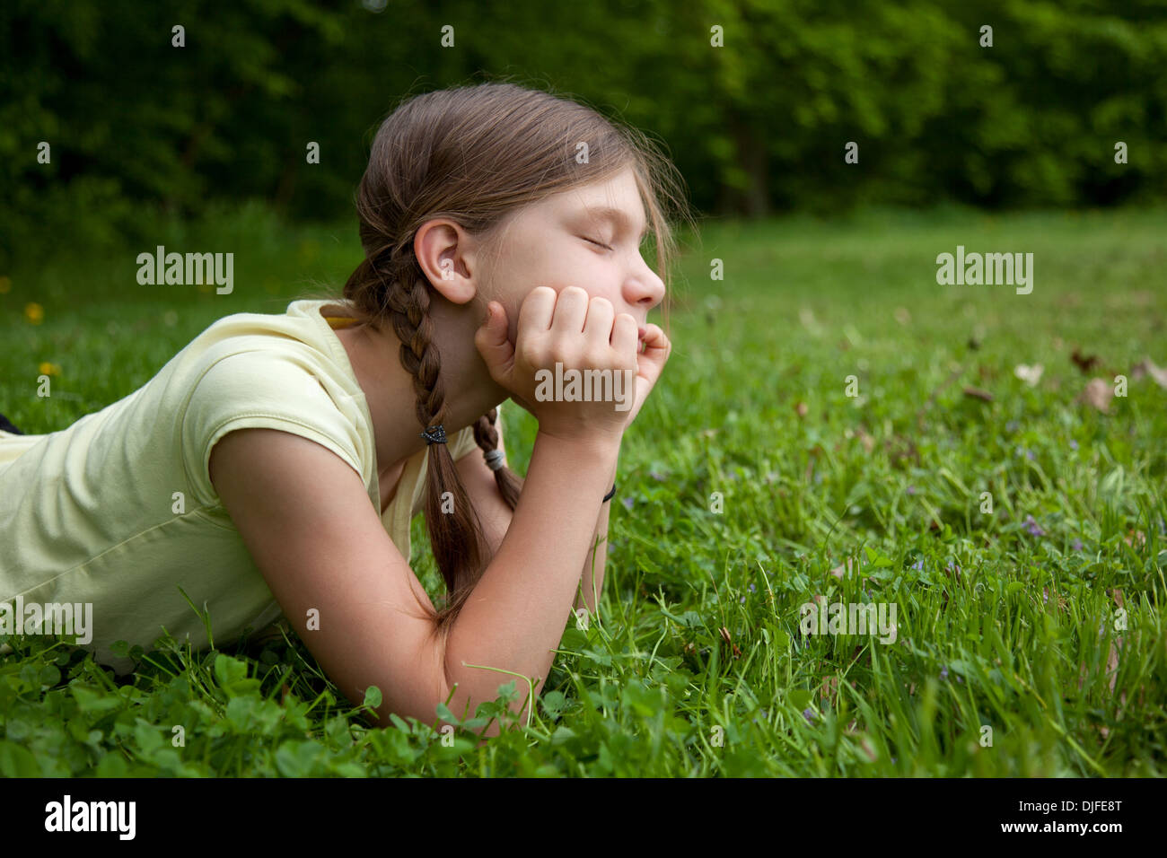 Porträt eines Mädchens in einem Park auf einer grünen Wiese denken Stockfoto