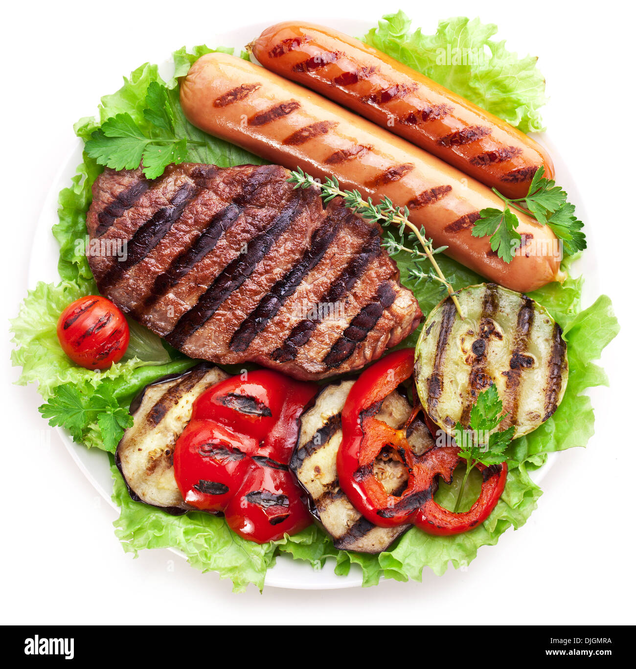 Gegrilltes Steak, Wurst und Gemüse über Salatblätter. Stockfoto