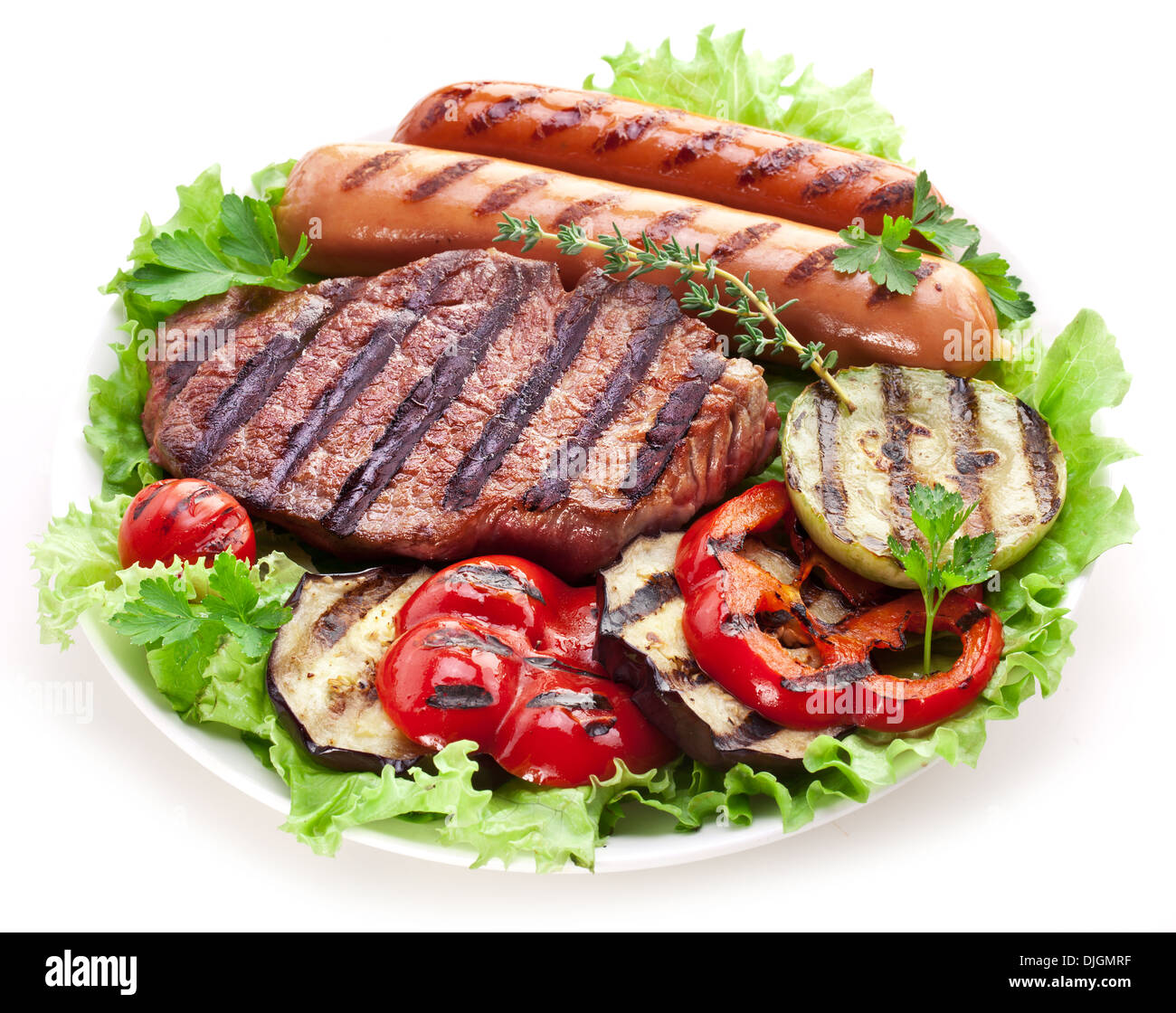 Gegrilltes Steak, Wurst und Gemüse über Salatblätter. Stockfoto