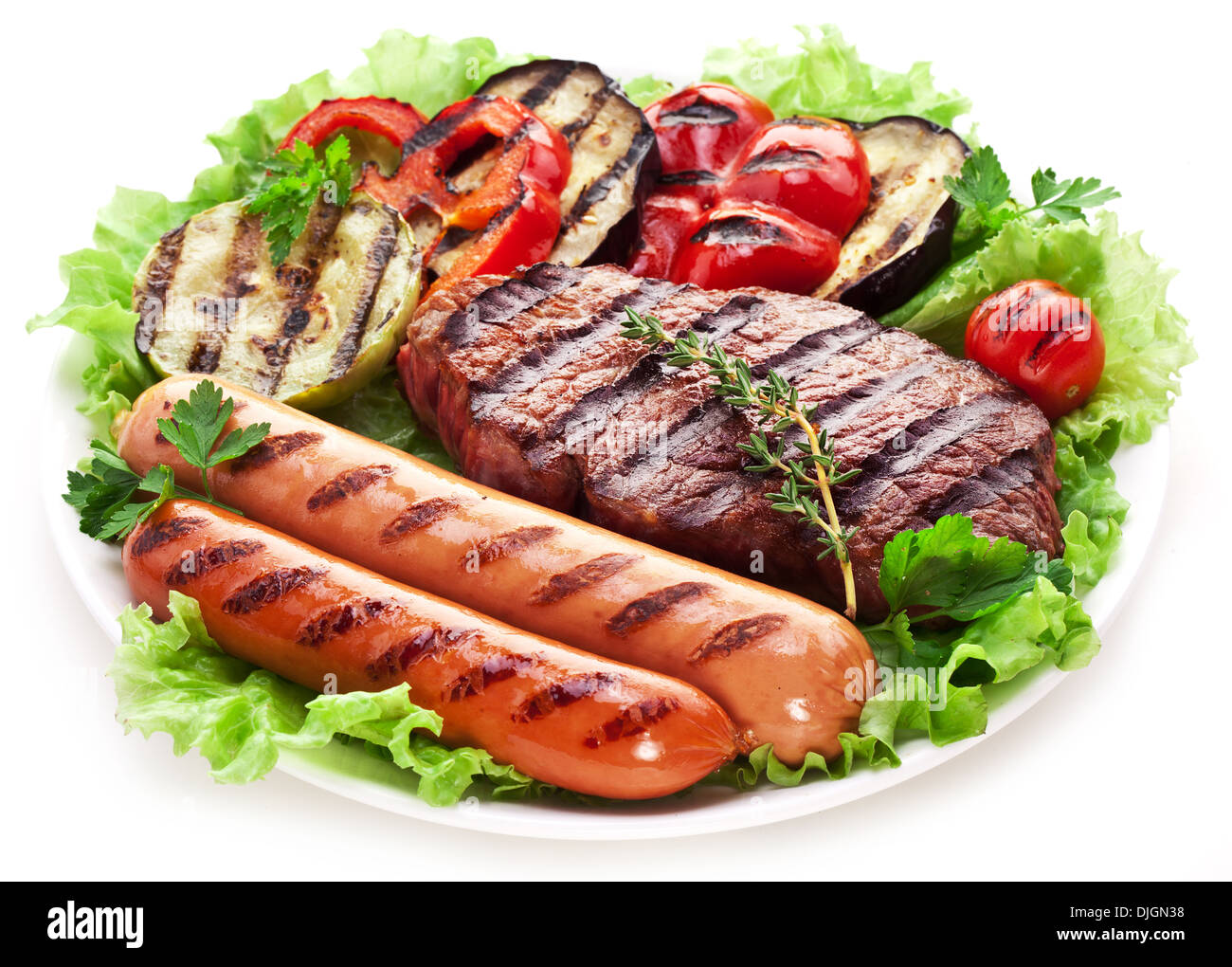 Gegrilltes Steak, Wurst und Gemüse über Salatblätter. Stockfoto
