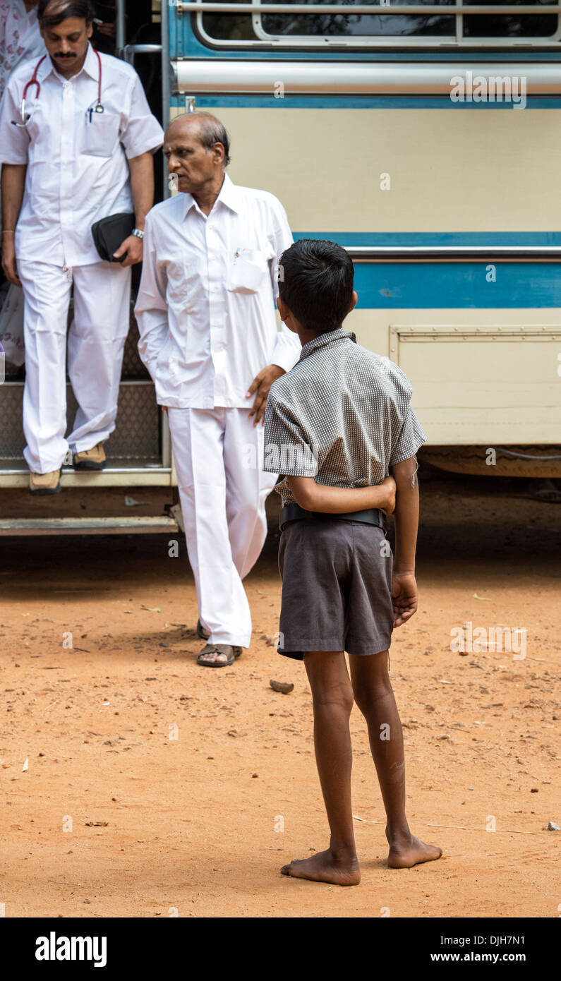 Indischer junge Ärzte Aussteigen aus dem Bus zu Sathya Sai Baba mobile aufsuchende Krankenhausservice betrachten. Andhra Pradesh, Indien. Stockfoto