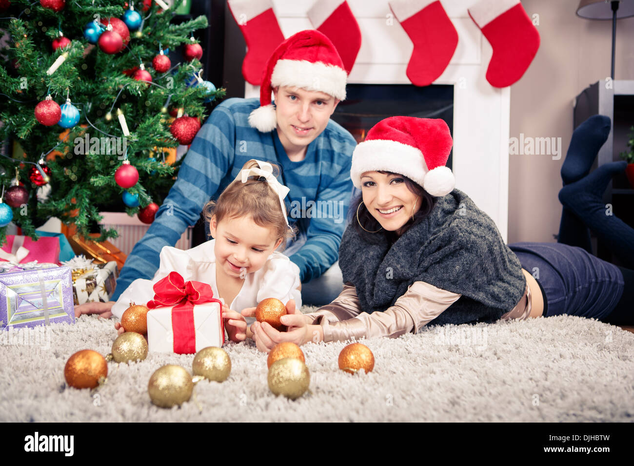 junge Familie vor Weihnachtsbaum Stockfoto