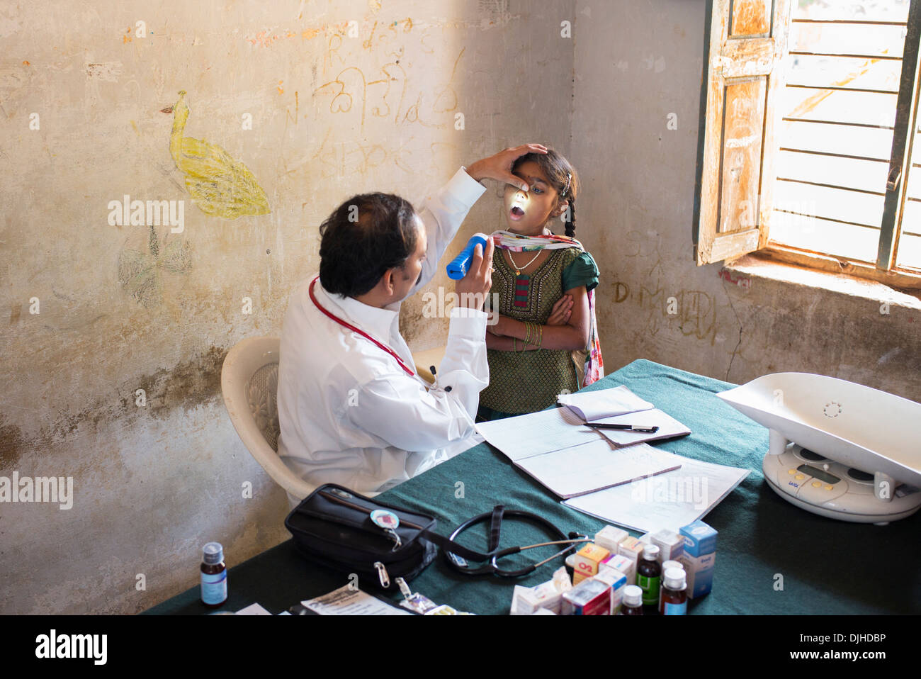 Pädiatrische indischen Arzt untersuchen eines jungen Mädchens in Sri Sathya Sai Baba mobile aufsuchende Krankenhausklinik. Andhra Pradesh, Indien Stockfoto