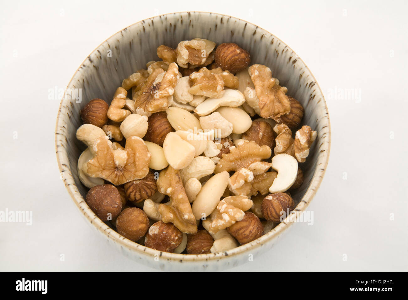 Schüssel mit gemischten Nüssen mit weißem Hintergrund hautnah Stockfoto