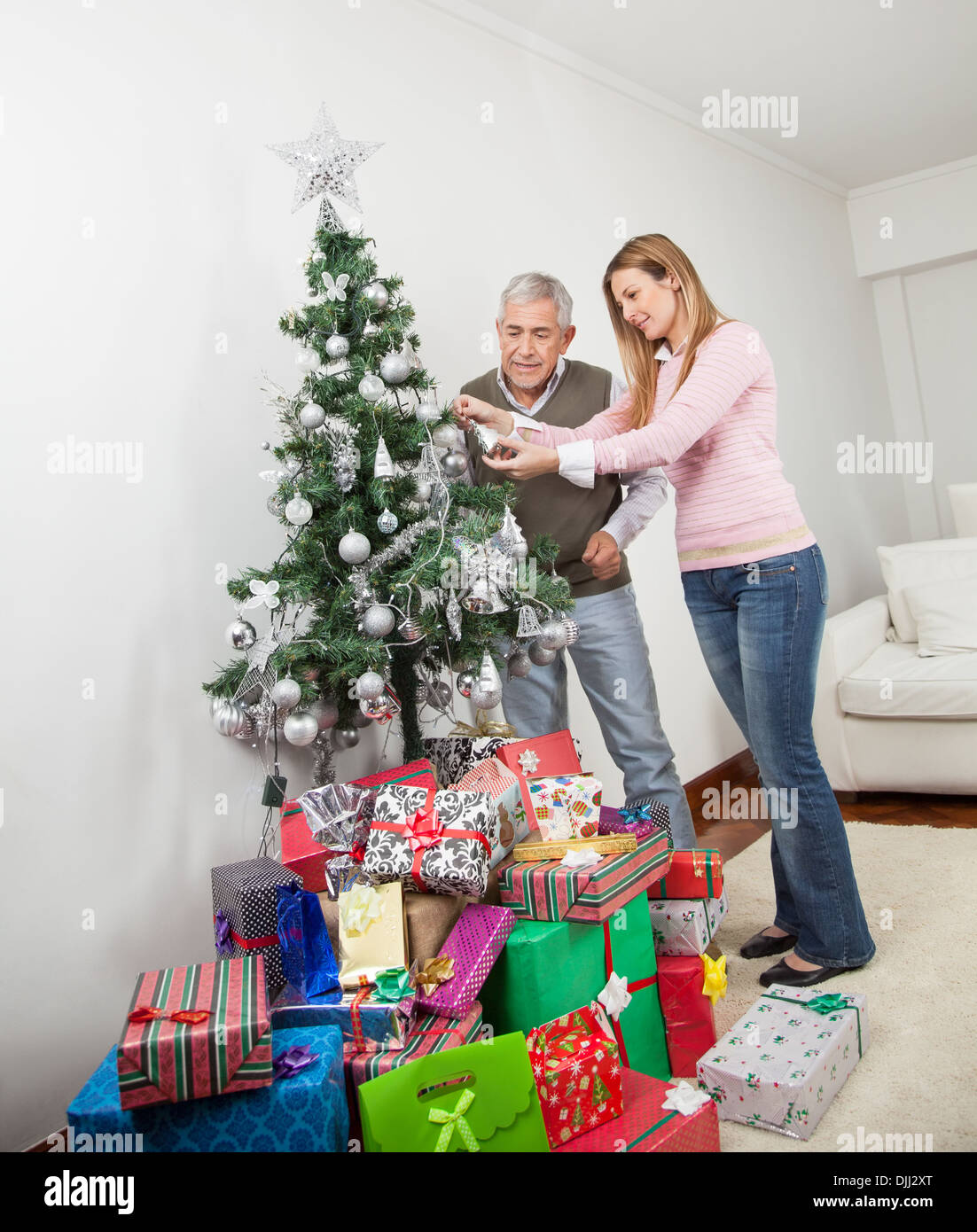 Ältere Mann und Tochter schmücken Weihnachtsbaum Stockfoto