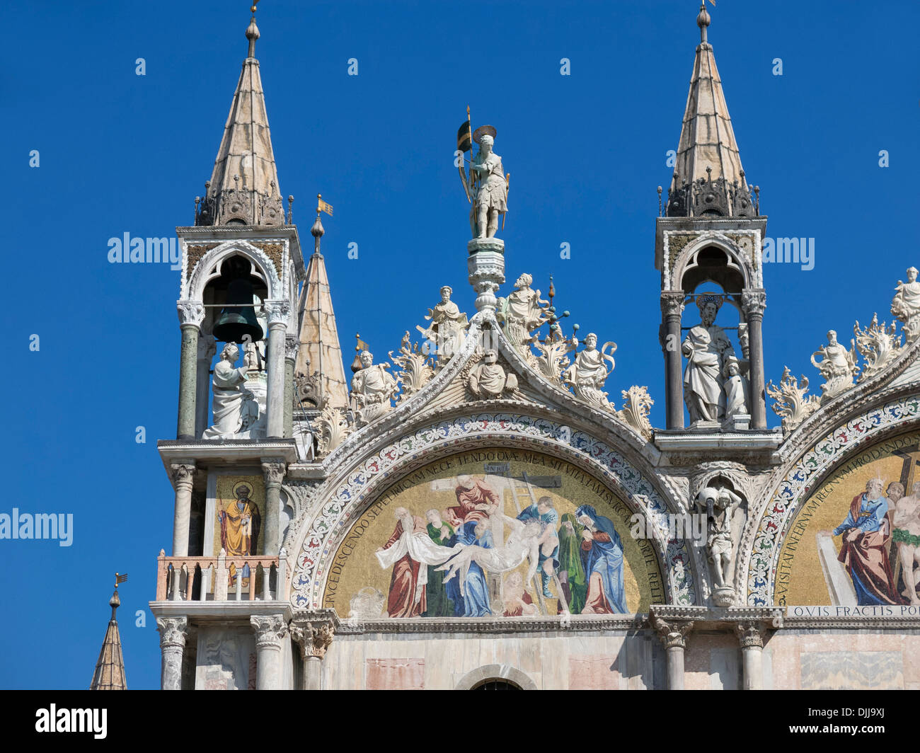 Reich verzierte Türme, religiöse Mosaike und geschnitzten Stein Brüstungen gegen blauen Himmel, Basilika St. Marco, Venedig, Italien Stockfoto