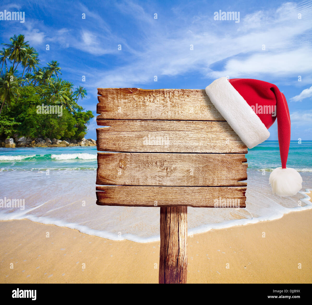 Weihnachten am Strand. Hölzerne Schild mit der Weihnachtsmütze. Stockfoto