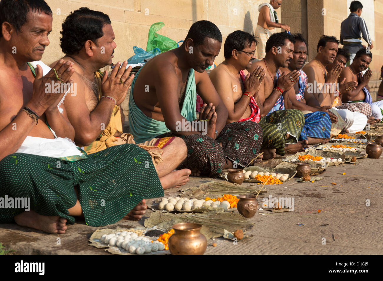 Eine Gruppe von Hindus beten mit einem religiösen Führer, der sie leitet. Stockfoto