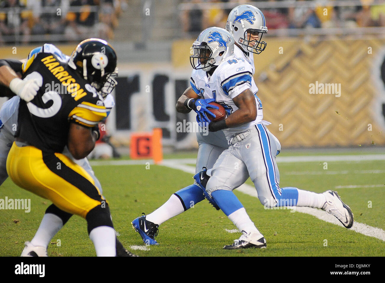 14. August 2010 - Pittsburgh, PENNSYLVANNIA, Vereinigte Staaten von Amerika - 14. August 2010: Detroit Lions Quarterback MATTHEW STAFFORD (9) macht die Übergabe an Detroit Lions Runningback JAHVID BEST (44) im ersten Quartal wie Pittsburgh Steelers offensive Linebacker JAMES HARRISON (92) nach außen durch die offensive Line Löwen gehalten wird, wie die Pittsburgh Steelers auf der Detroi Stockfoto