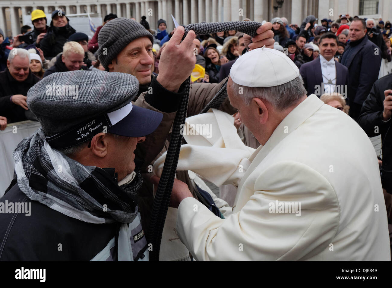 Vatikan, Rom, Italien. 27. November 2013. Papst Francis, während ein sehr kalter Tag im Piazza San Pietro, ändern seinen Schal mit einer Kranken Person und seine Helfer in der Generalaudienz vom 27. November 2013 Credit: wirklich Easy Star/Alamy Live News Stockfoto