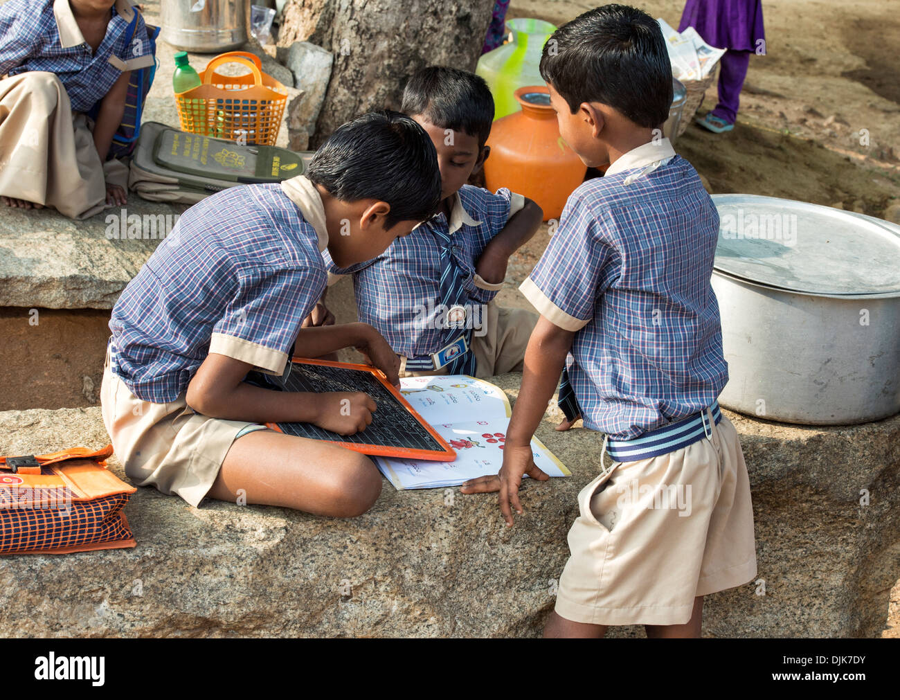 Indische Bauerndorf Schuljungen Telegu auf einem Kreide-Tablet in einer externen Klasse schreiben. Andhra Pradesh, Indien Stockfoto